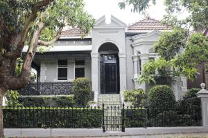 Front view of a restored Victorian terrace house with ornate façade and landscaped garden